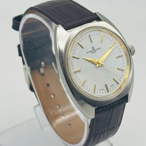 May include: A silver wristwatch with a white face and gold hands. The watch features the brand name "ULYSSE NARDIN" and an anchor logo. It has a dark brown leather strap.
