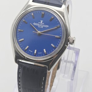 May include: A silver-toned Jaeger-LeCoultre Club watch with a deep blue face and silver hands. The watch has a black leather band with white stitching. The watch face displays the Jaeger-LeCoultre logo and the word "CLUB".