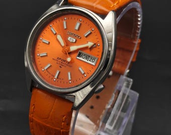 Reloj de pulsera automático vintage Seiko 5 para hombre, con fecha y día, esfera deportiva naranja, fabricado en Japón.