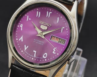 Reloj de pulsera automático Seiko 5 vintage para hombre con fecha, día y esfera árabe morada.