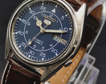 Reloj de pulsera automático Seiko 5 para hombre, estilo vintage de los años 90, con fecha y día, color azul, con indicación de hora en el ferrocarril.