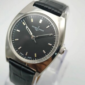 Puede incluir: Un reloj de pulsera plateado con esfera negra y correa de cuero negro. La esfera del reloj presenta marcadores de hora y agujas plateadas. Se muestra la marca "ULYSSE NARDIN". Dise&ntilde;o cl&aacute;sico y elegante.
