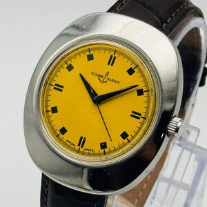 May include: A vintage Ulysse Nardin wristwatch with a silver case and a bright yellow dial. The watch has black hour markers and hands, and a brown leather strap. The watch face displays the text "Ulysse Nardin" and "Swiss Made".