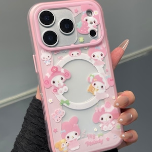 May include: Pink phone case with a clear back and a pink border. The case features cartoon characters, stars, and the text "My Melody". The case has cutouts for the phone's camera and buttons.