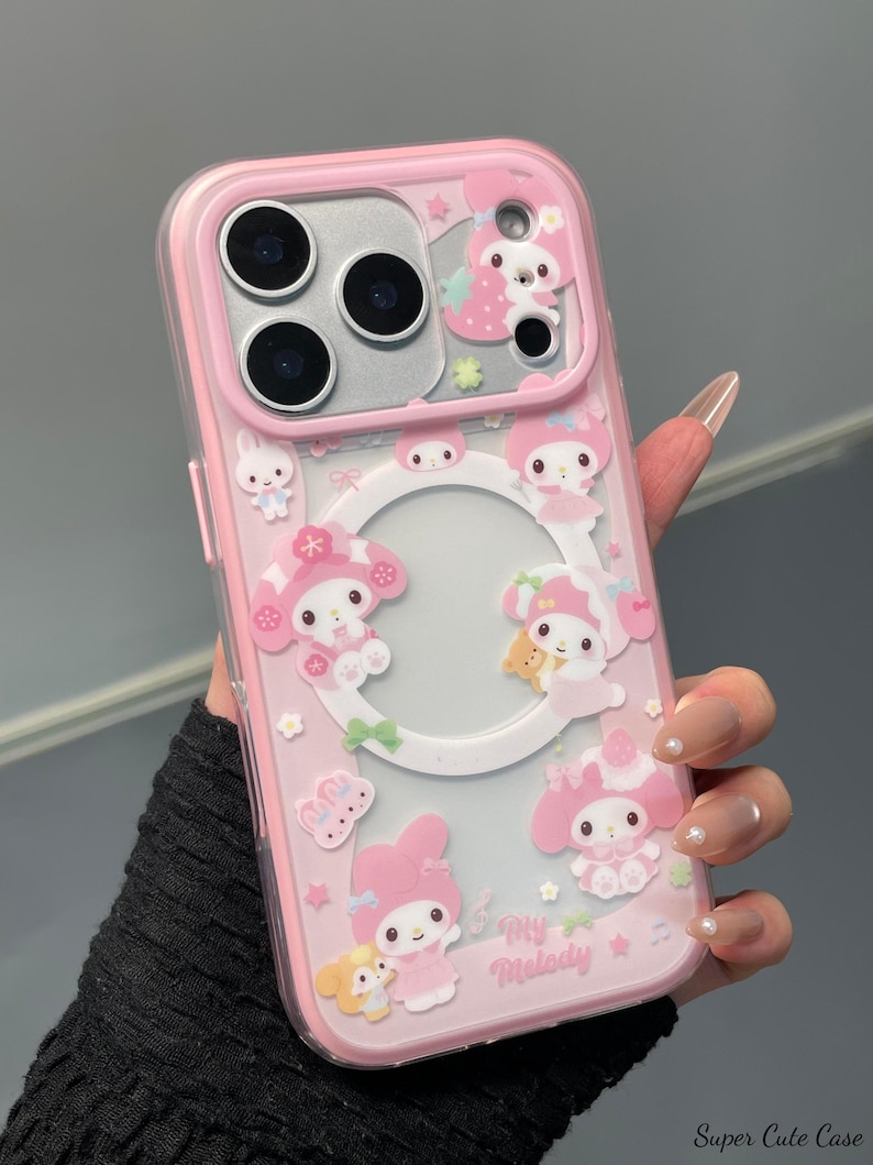 May include: Pink phone case with a clear back and a pink border. The case features cartoon characters, stars, and the text "My Melody". The case has cutouts for the phone's camera and buttons.