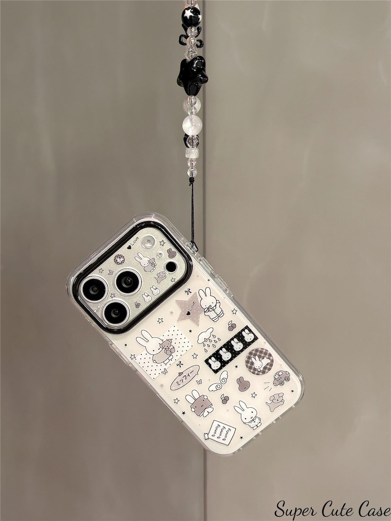 Pode incluir: Capa de telefone transparente com um design de coelho branco e preto. A capa tem uma borda preta para a c&acirc;mera e uma al&ccedil;a decorativa com contas pretas e brancas. O texto "Super Cute Case" &eacute; vis&iacute;vel.