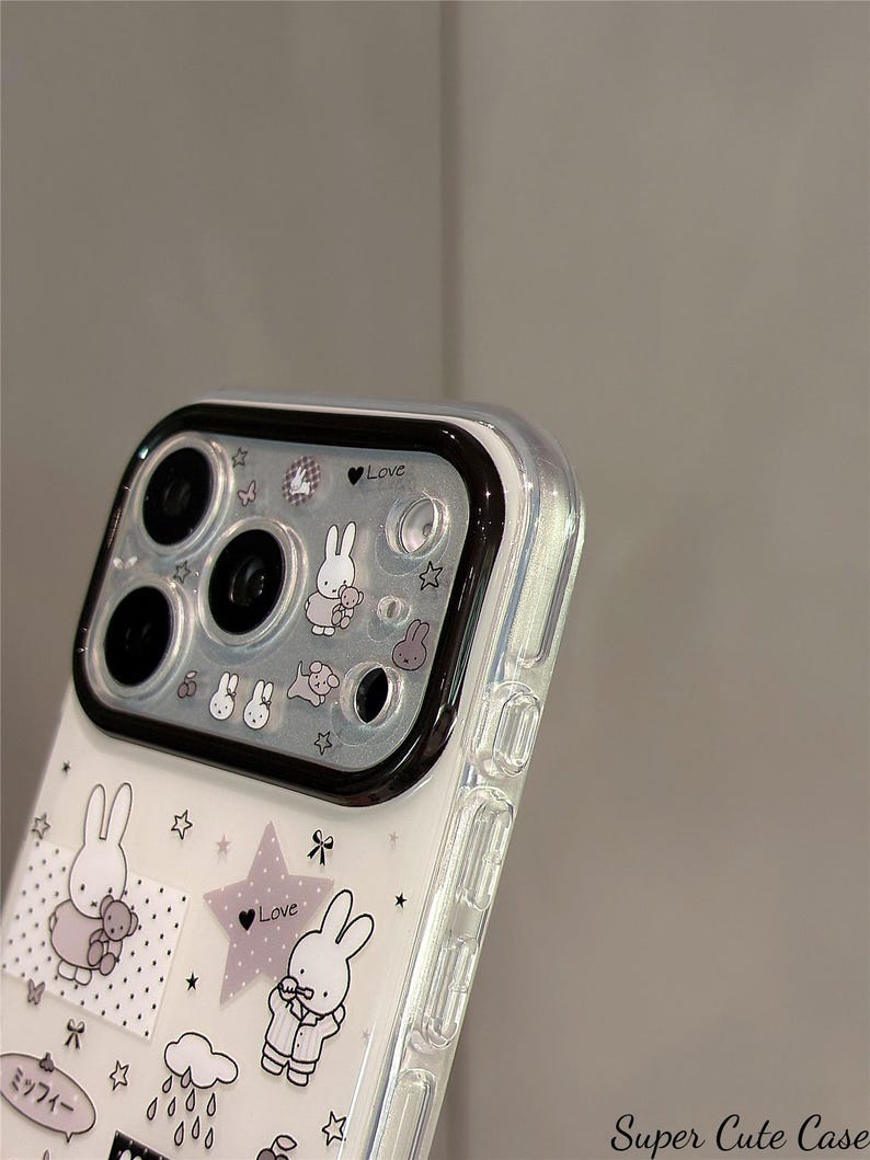 Pode incluir: Capa de telefone transparente decorada com coelhos de desenho animado, estrelas e a palavra "Love" em uma estrela roxa. A capa tem uma borda preta para a c&acirc;mera e o texto "Super Cute Case" no canto inferior direito.