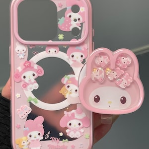 May include: Pink phone case with a clear center and a matching pop-up grip. The case features cartoon characters, strawberries, and stars. The pop-up grip has a My Melody design. The text "Super Cute Case" is visible in the bottom right corner.