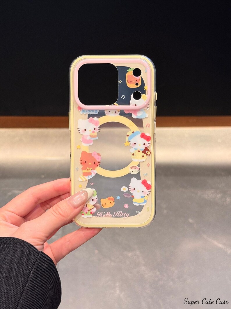 Peut inclure: Une coque de t&eacute;l&eacute;phone transparente avec un bord jaune et un motif Hello Kitty. La coque pr&eacute;sente divers personnages et aliments Hello Kitty. Le texte "Hello Kitty" est visible sur la coque.