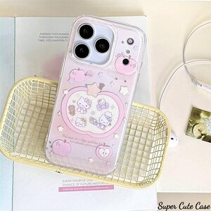 May include: Clear iPhone case with a pink apple design featuring cartoon characters and stars. The case has a clear border and a pink background. The text "Super Cute Case" is visible at the bottom right.