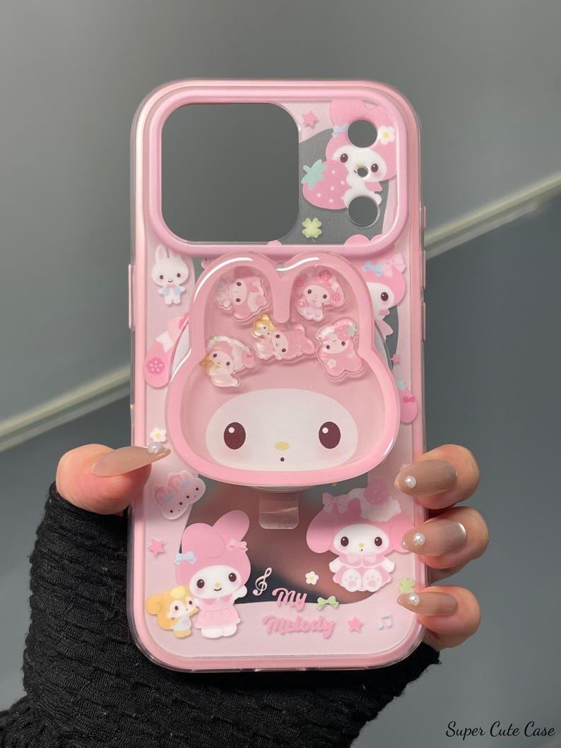 May include: Pink phone case featuring a My Melody design. The case has a clear back with pink accents and a raised My Melody character. Additional character graphics and the text "my Melody" are also visible.