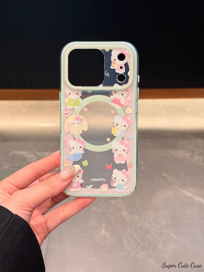 May include: A clear phone case featuring a pink and mint green border with Hello Kitty characters. The case has a clear center and a camera cutout. The Hello Kitty characters are in various poses and outfits. The text "HelloKitty" is printed on the case.