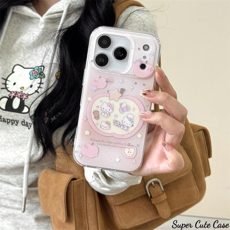 May include: Clear iPhone case with a pink apple design featuring Hello Kitty characters. The case has a clear border and a pink background with small stars and apple illustrations. The text "Super Cute Case" is at the bottom.
