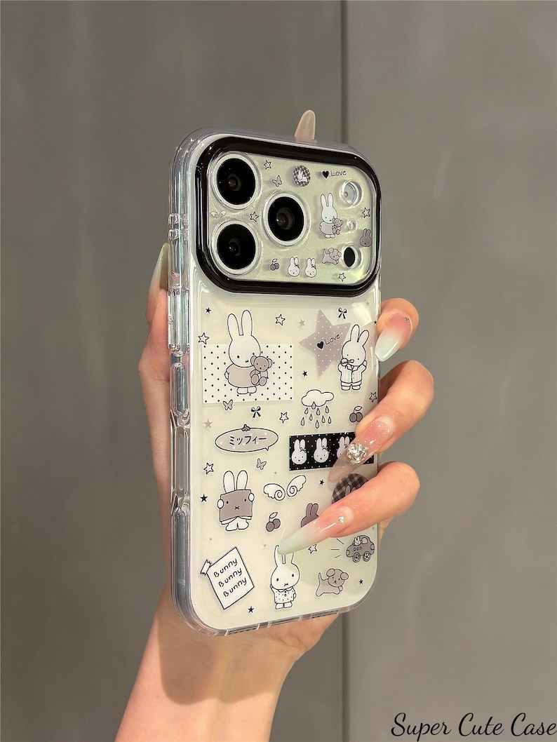 Pode incluir: Capa de telefone transparente com design de coelhos de desenho animado e estrelas. A capa inclui o texto "Love" e "Bunny Bunny Bunny". A capa &eacute; segurada por uma pessoa.
