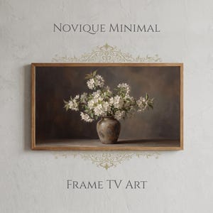 May include: A framed artwork featuring a still life of white flowers in a brown vase. The artwork is set against a dark background, with the words "NOVIQUE MINIMAL" and "FRAME TV ART" displayed above and below the frame.