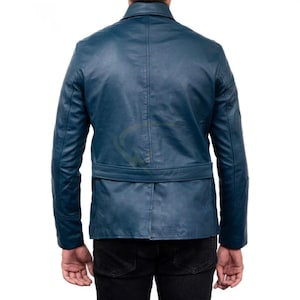 May include: A teal blue leather jacket with a notched collar and a belt at the waist. The jacket has long sleeves and a tailored fit. The back view shows the jacket's design and stitching details. The jacket is worn over black pants.