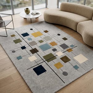May include: A rectangular area rug with a light gray base featuring a geometric pattern of various sized squares and circles in shades of mustard yellow, navy blue, olive green, light blue, and cream, connected by thin black and gray lines.