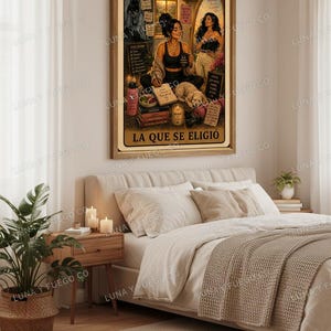 May include: A framed print featuring a woman in a black top and leggings, seated with a dog, books, and candles. The print includes the text "LA QUE SE ELIGI&Oacute;". The artwork is displayed above a bed with neutral-toned bedding and a woven throw.
