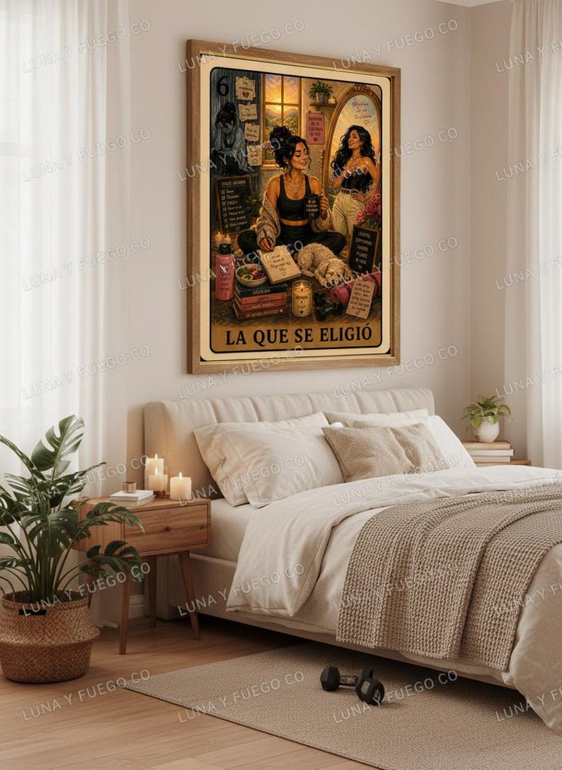 May include: A framed print featuring a woman in a black top and leggings, seated with a dog, books, and candles. The print includes the text "LA QUE SE ELIGI&Oacute;". The artwork is displayed above a bed with neutral-toned bedding and a woven throw.