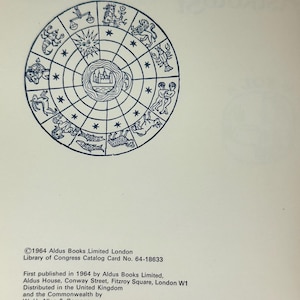 May include: A vintage book page featuring a detailed illustration of a zodiac wheel in blue ink. The wheel is divided into segments, each depicting a zodiac sign. Text at the bottom includes the publisher's information and copyright details.