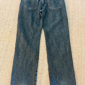 K&ouml;nnte beinhalten: Blaue Jeans aus Denim mit klassischem F&uuml;nf-Taschen-Design. Die Jeans haben einen geraden Beinverlauf und eine ausgewaschene Optik. Die Ges&auml;&szlig;taschen sind quadratisch und mit N&auml;hten verst&auml;rkt. Ein kleines rotes Etikett ist sichtbar.