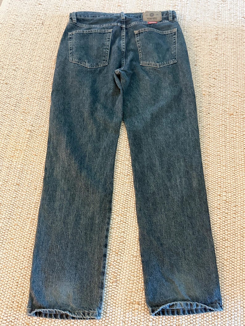 K&ouml;nnte beinhalten: Blaue Jeans aus Denim mit klassischem F&uuml;nf-Taschen-Design. Die Jeans haben einen geraden Beinverlauf und eine ausgewaschene Optik. Die Ges&auml;&szlig;taschen sind quadratisch und mit N&auml;hten verst&auml;rkt. Ein kleines rotes Etikett ist sichtbar.