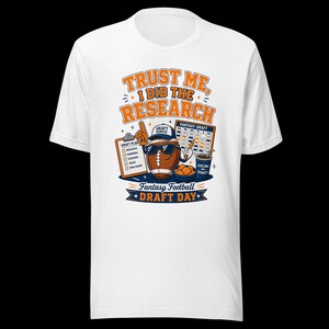 Könnte beinhalten: Ein weißes T-Shirt mit einer Grafik eines braunen Footballs, der eine Sonnenbrille und eine Kappe trägt und einen Stift sowie einen Schaumstofffinger mit der Nummer eins hält. Der Text lautet TRUST ME, I DID THE RESEARCH, FANTASY DRAFT und FANTASY FOOTBALL DRAFT DAY.