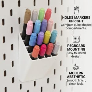 Peut inclure: Un organisateur en plastique blanc avec plusieurs compartiments carr&eacute;s mont&eacute; sur un panneau perfor&eacute; blanc, contenant divers marqueurs color&eacute;s. Le texte &agrave; droite indique : HOLDS MARKERS UPRIGHT, PEGBOARD MOUNTING et MODERN AESTHETIC.