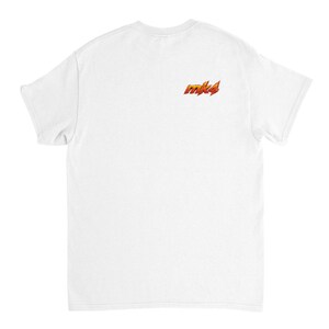 May include: A white t-shirt with a small, stylized "mk4" logo in orange and yellow on the upper back. The shirt is plain and has short sleeves.