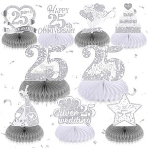 May include: A collection of silver glitter 25th anniversary honeycomb centerpieces featuring various designs including hearts, a cake, champagne bottles, and stars with text such as Happy 25th Anniversary, 25 years, Cheers 25, and Silver 25 wedding.