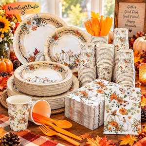 May include: A set of disposable party supplies featuring a fall-themed pattern of white pumpkins, orange flowers, and brown branches. The collection includes stacks of paper plates, paper cups, orange plastic forks and spoons, and paper napkins.