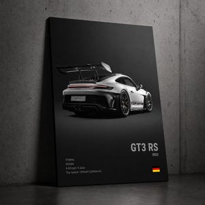 Peut inclure: Une affiche murale rectangulaire verticale représentant une voiture de sport Porsche 911 GT3 RS blanche sous un angle arrière trois-quarts. Le texte indique GT3 RS 2022, 510bhp, 465Nm, 0-62mph: 3.2sec, Top speed: 184mph (295km/h) avec un drapeau allemand.