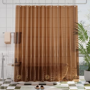 May include: A translucent brown shower curtain with a vertical ribbed texture, suspended from a silver metal rod by circular rings. The curtain features three reinforced metal grommets along the bottom edge and hangs in front of a white bathtub.