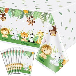 May include: A white rectangular plastic tablecloth featuring a repeating jungle theme with watercolor illustrations of a lion, elephant, tiger, zebra, giraffe, and monkey, accented by green tropical leaves and grass on a white background.