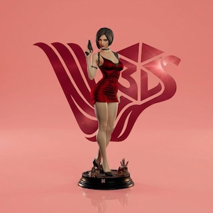 May include: A detailed figurine of a woman in a red dress holding a black handgun. The figure stands on a black base with a red and pink background. The figurine has a short black bob and is wearing black heels.