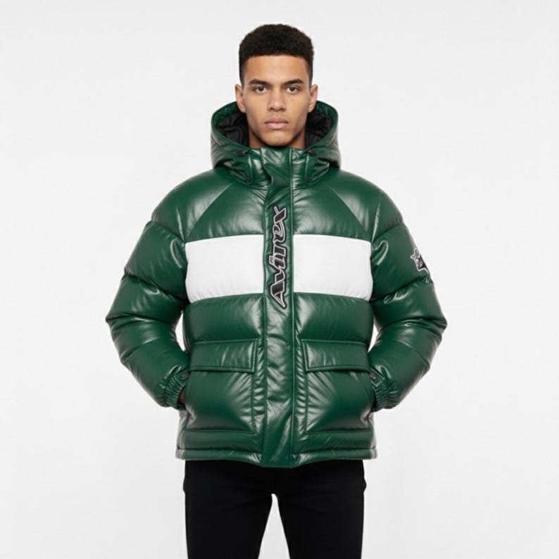 May include: Green puffer jacket with a white stripe across the chest. The jacket has a hood and two front pockets. The brand name "Avirex" is vertically displayed in white on the front.