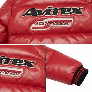May include: Red puffer jacket with the brand name "Avirex" and "All Star Dualers" embroidered on the chest. The jacket has a quilted design and a black and red striped cuff.