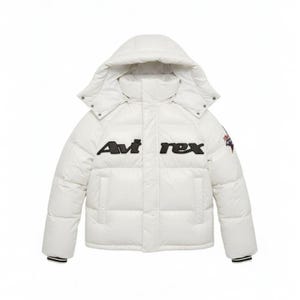 May include: A white hooded puffer jacket with the text "Avirex" in black across the chest. The jacket has a zip closure, a hood, and black trim on the cuffs and hem. The jacket is designed for cold weather.