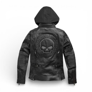 Könnte beinhalten: Schwarze Motorradjacke aus Leder mit Kapuze. Auf der Rückseite befindet sich ein Harley-Davidson-Logo mit einem Totenkopf-Emblem. Die Jacke hat gerippte Details an den Ärmeln und Reißverschlusstaschen. Ein klassischer Biker-Stil.