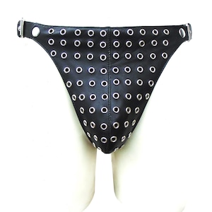 Op de afbeelding: Een zwarte leren jockstrap met een raster van zilverkleurige metalen oogjes op het voorpaneel. Het kledingstuk is voorzien van een centrale verticale naad en verstelbare zijbanden die zijn vastgezet met zilverkleurige metalen gespen en drukknopen.