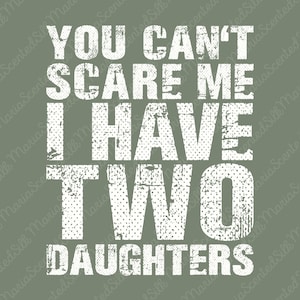 Könnte beinhalten: Ein salbeigrünes Grafikdesign mit dem weißen, abgenutzten Text YOU CAN'T SCARE ME I HAVE TWO DAUGHTERS. Die Schrift ist fett, im Blockstil gehalten und weist ein verwittertes, abgenutztes Aussehen auf dem einfarbigen, gedeckten grünen Hintergrund auf.