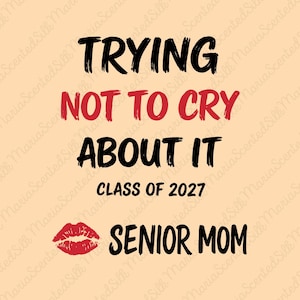 May include: A light peach graphic design featuring the black text TRYING, the red text NOT TO CRY, the black text ABOUT IT, the black text CLASS OF 2027, a red lipstick kiss mark, and the black text SENIOR MOM centered on the page.