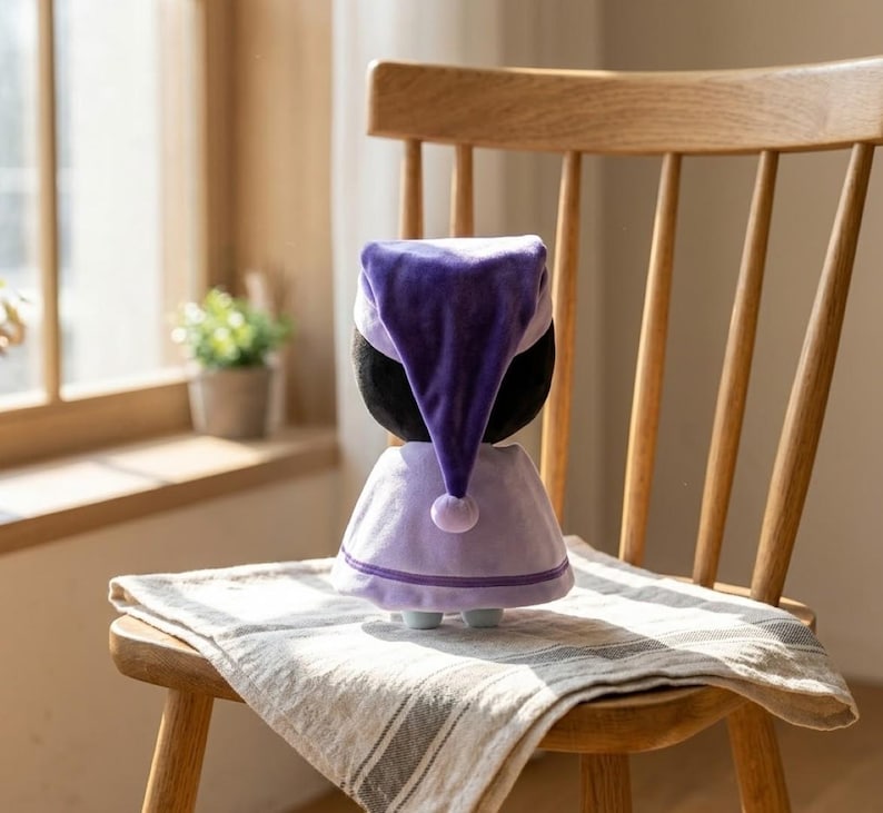 May include: A plush doll wearing a purple nightcap and a matching dress, trimmed with light purple and a small pom-pom. The doll is on a wooden chair with a striped cloth.