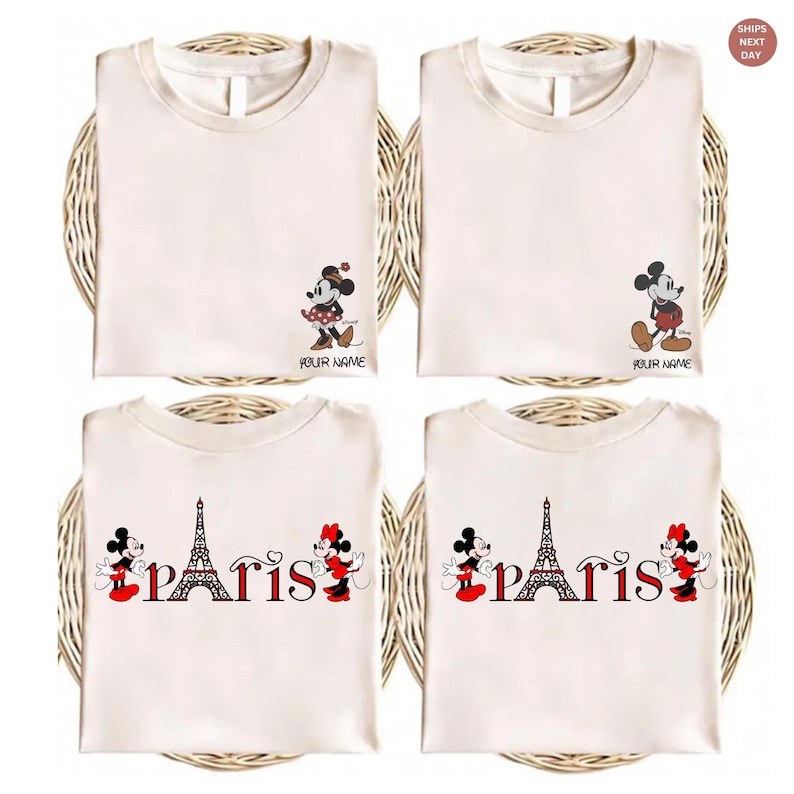 May include: Four cream-colored t-shirts with cartoon character designs. Two shirts feature Mickey and Minnie Mouse, and the other two have the Eiffel Tower and the word "Paris". Each shirt has the text "YOUR NAME".
