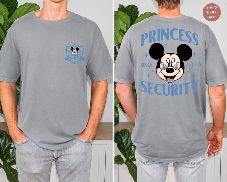 May include: Gray t-shirt featuring a Mickey Mouse graphic on the front and back. The front has a small emblem with Mickey. The back displays "PRINCESS SECURITY SINCE 2026" with Mickey wearing sunglasses. A fun, casual tee.