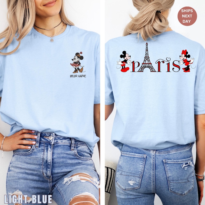 May include: Light blue t-shirt featuring Minnie Mouse and the word "Paris" with the Eiffel Tower. The front of the shirt has a Minnie Mouse graphic and the text "Your Name". The back of the shirt has the word "Paris" with Minnie Mouse graphics.