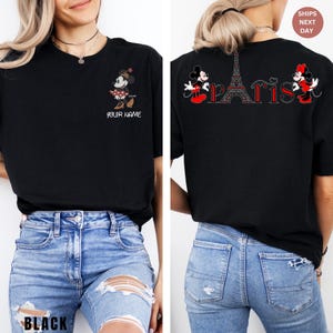 May include: Black t-shirt featuring Minnie Mouse in a red and white polka dot dress, with the text "YOUR NAME" below. The back of the shirt has a design with the Eiffel Tower and the word "PARIS" with Minnie Mouse on each side.