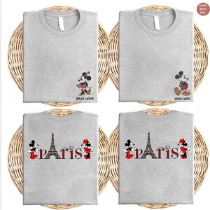 May include: Four gray t-shirts with different designs. Two shirts feature Mickey and Minnie Mouse with the text "YOUR NAME". The other two shirts have the word "PARIS" with the Eiffel Tower and Mickey and Minnie Mouse.
