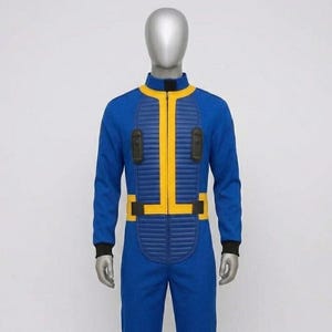 Full front view of the standard Fallout Vault Dweller costume jumpsuit on a mannequin, featuring textured blue fabric, ribbed yellow collar, matching central chest zipper, waist belt, and padded black tech pouches.