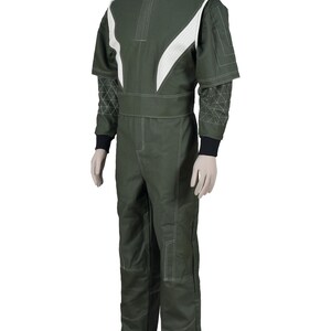May include: A dark olive green jumpsuit featuring white paneling on the shoulders and chest, a high collar, and white contrast stitching throughout. The sleeves have a geometric triangular pattern, and the cuffs are finished with black fabric.